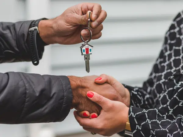 This is a person handing a key for a housing market property.
